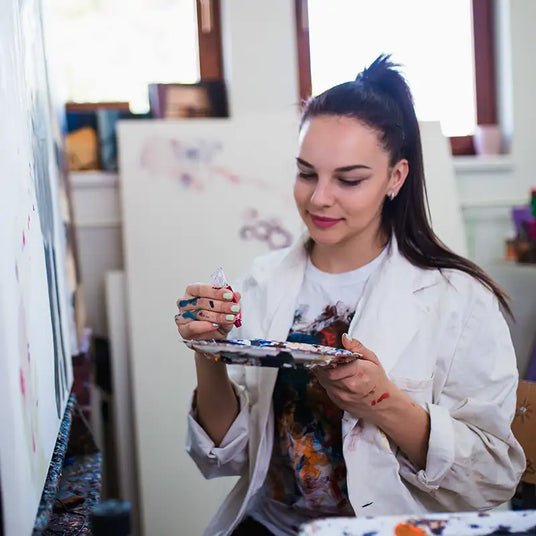 Woman artist holding a paint palette and brush.