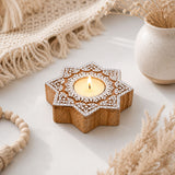 Star-shaped wooden block print tea light candle holder with white carved patterns and lit tlight for diwali decoration