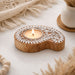 Wooden block print tealight holder with white laser-cut floral patterns and natural wood finish for Diwali decoration