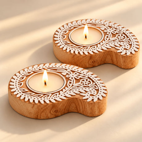 Two handcrafted wooden block print tealight holders with intricate paisley and floral patterns for festive home decor
