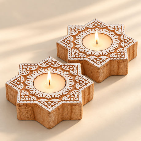 Handcrafted star-shaped wooden tealight holders with intricate white carved patterns for festive home decor