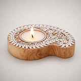 A light brown wooden tealight holder with intricate white carved floral patterns for diwali decoration and worship