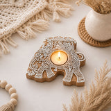 A carved wooden elephant tea light candle holder with intricate white lace patterns for Diwali decoration