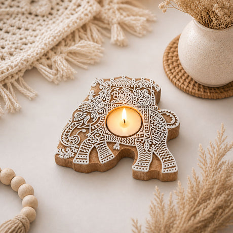 A carved wooden elephant tea light candle holder with intricate white lace patterns for Diwali decoration