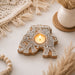A carved wooden elephant tea light candle holder with intricate white lace patterns for Diwali decoration