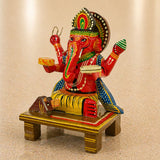 Wooden ganesha statue kondapalli hand painted with red body green and gold accents seated on tiger for pooja and home decor