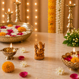 Golden ganesha figurine with intricate carvings and polished metallic finish for pooja and home decor