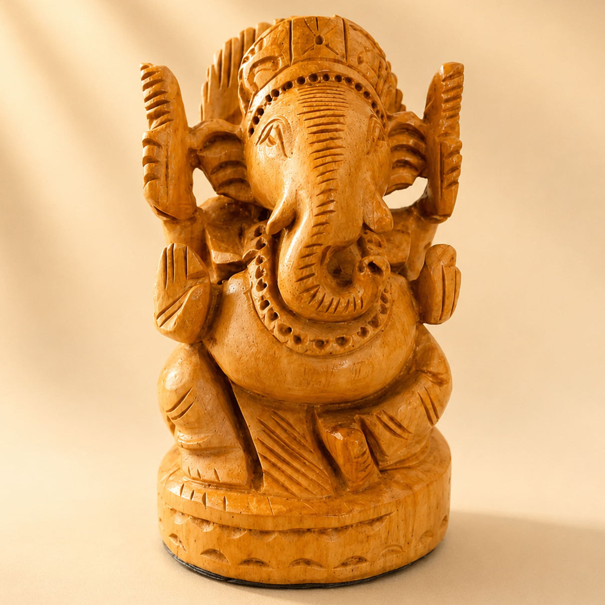 Hand-carved wooden ganesha idol with intricate details and warm golden-brown finish for pooja and home decor