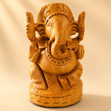 Hand-carved wooden ganesha idol with intricate details and warm golden-brown finish for pooja and home decor