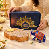 A decorative blue and gold elephant figurine with intricate floral patterns in a festive diwali gift hamper