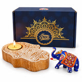 Hand-carved wooden diya with intricate white lace patterns and lit candle for Diwali gift hamper celebrations