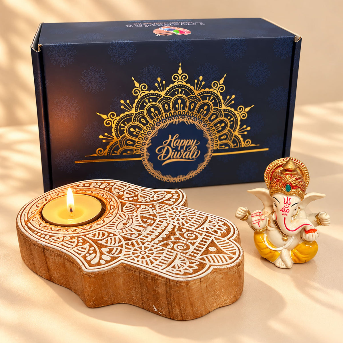 Hand-shaped wooden tealight holder with intricate white and gold engraved patterns in a diwali gift hamper