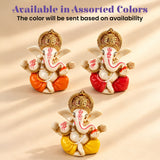 Three miniature ganesha figurines with white bodies and gold crowns in brightly colored robes in a diwali gift hamper