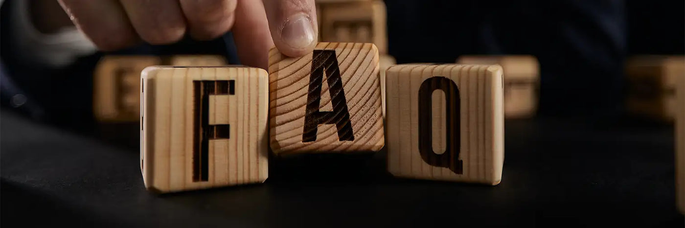 Wooden letter blocks spelling out ’FAQ’.