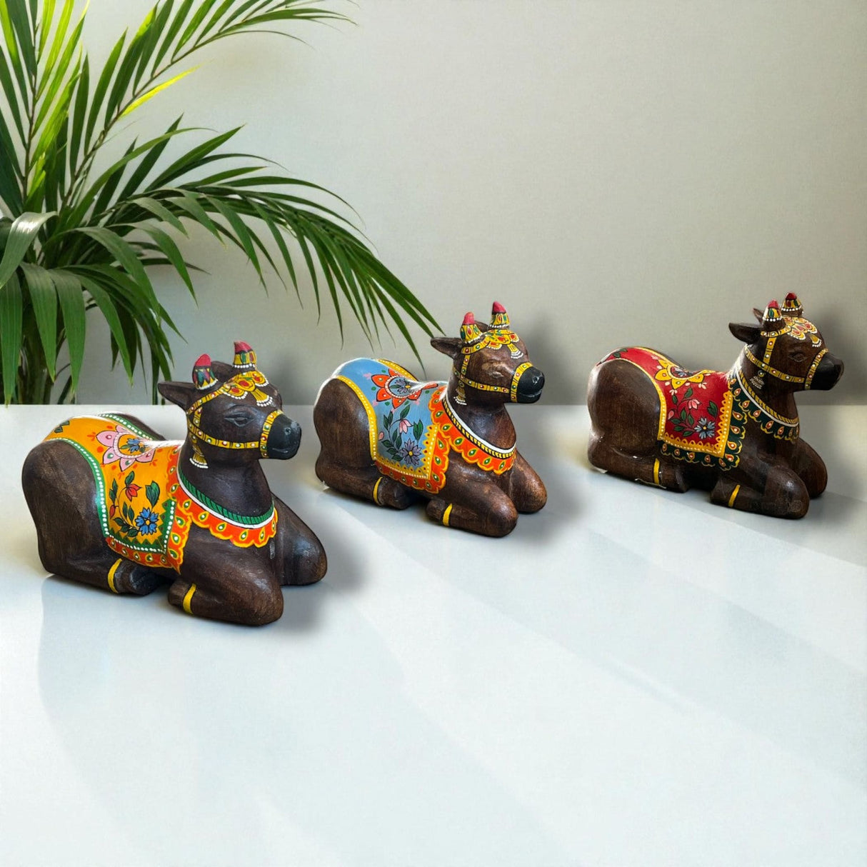 Hand-painted wooden Nandi cow idol in vibrant traditional attire