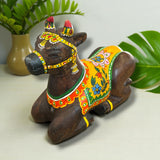 Handmade wooden Nandi cow idol with floral patterns and red headdress