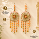 Pair of peach-colored pom-pom dreamcatcher wall hangings with gold metallic frames and bells for home decor
