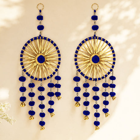 Blue and gold chandelier style earrings with intricate radial patterns pom pom accents and dangling bells for festive decor