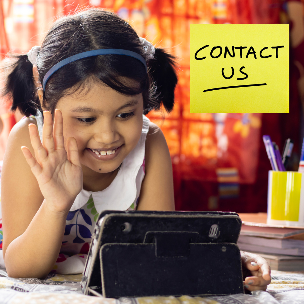 Smiling young girl wearing headphones while using a tablet device.